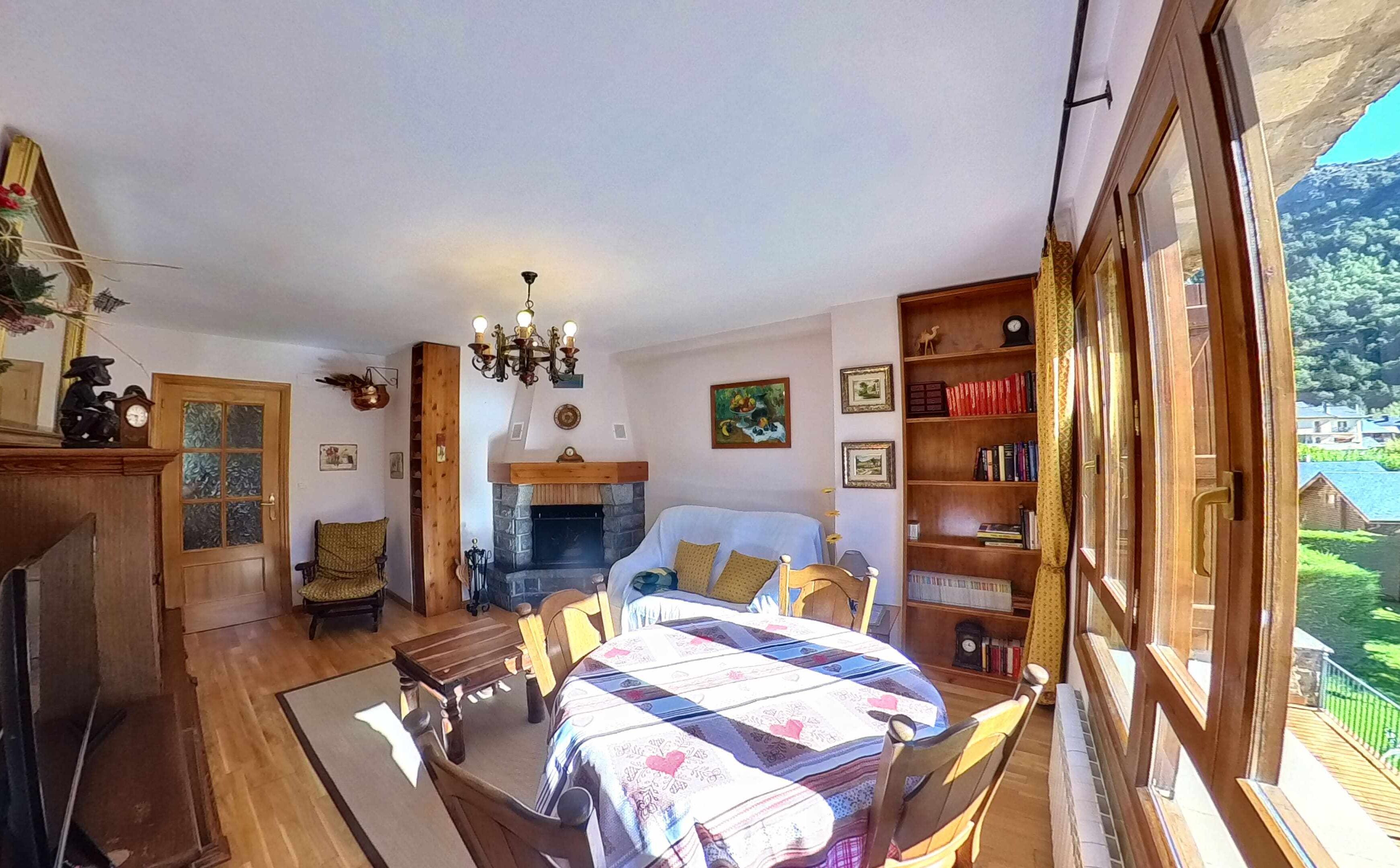 Um quarto aconchegante com lareira, uma cama grande, uma estante de madeira e vista para o exterior.