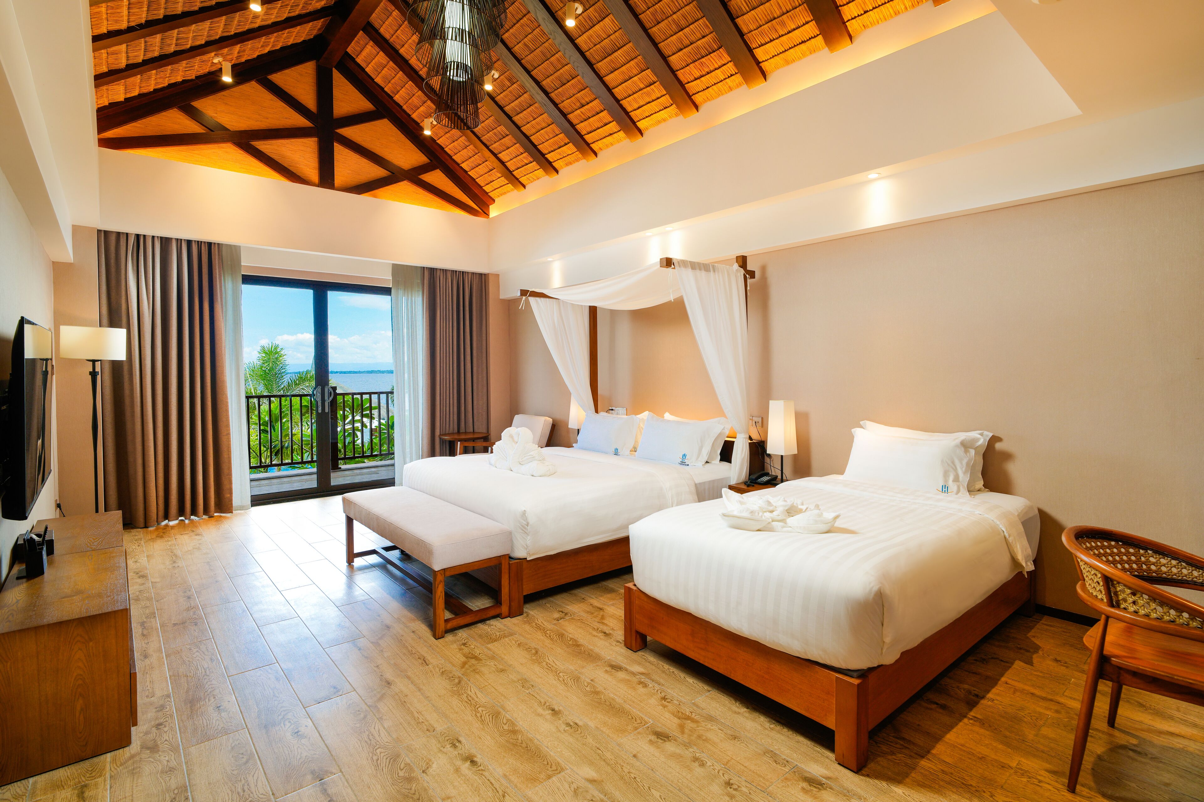 Habitación de hotel con dos camas, un balcón y techo de madera.
