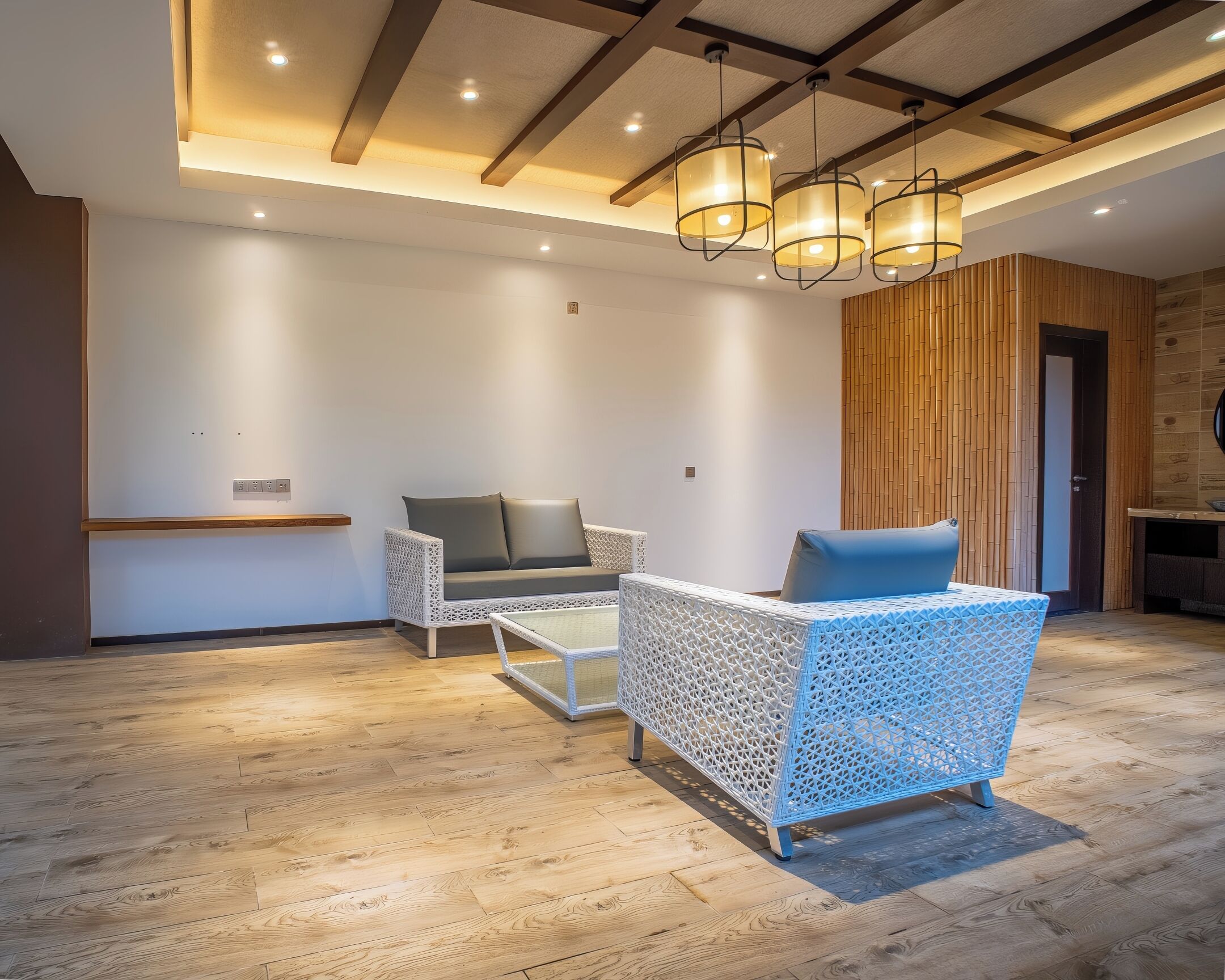 Een modern interieur met een houten vloer, witte muren en een zithoek met een witte geweven stoel en een blauwe, beklede bank.