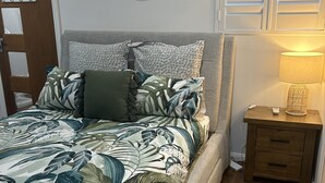 A bedroom with a bed, a nightstand, a lamp, and a window with blinds. - Pet friendly private studio, walking distance to lake  (Halekulani)