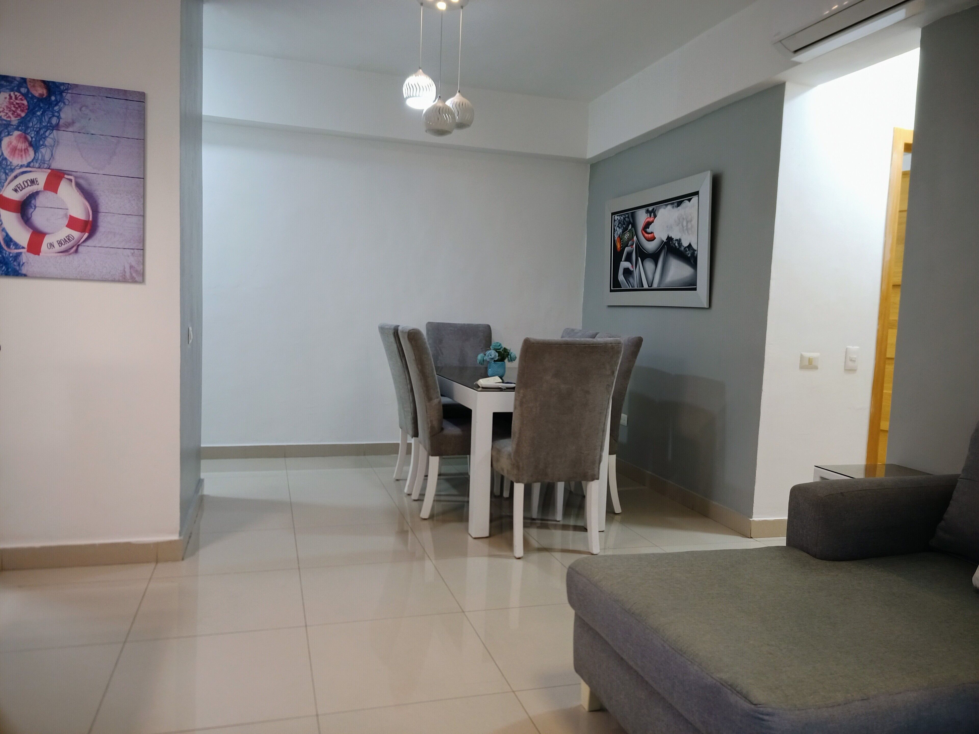 Un coin repas avec une table et des chaises, un canapé et un tableau accroché au mur.