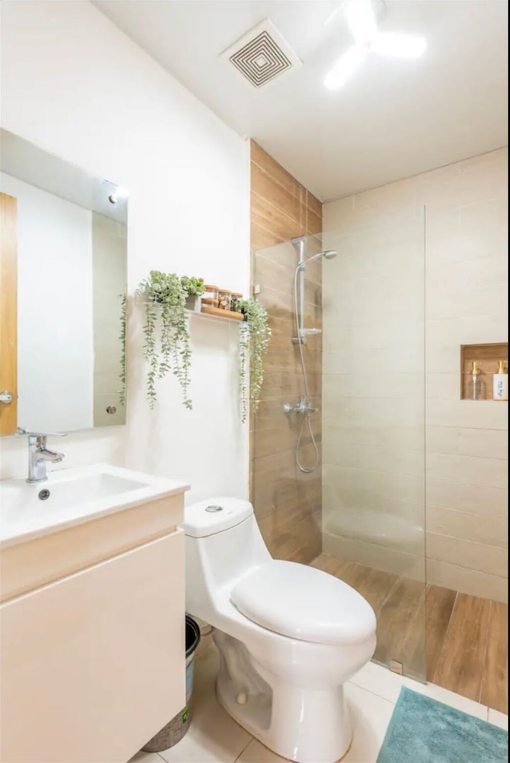 A modern bathroom with a white sink, toilet, and shower.