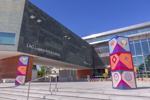 A modern building with a dark facade and a sign reading "LAC Lugarno Arte e Cultura."
