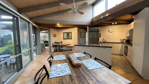 A spacious kitchen with modern appliances, a dining area with a large wooden table, and a ceiling fan. - This Pet Friendly property is the perfect escape to the beauty of Inverloch (Inverloch)