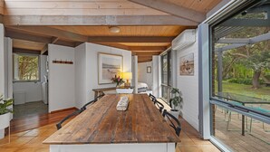 A spacious dining area with a wooden table, chairs, and a view of the outdoors. - This Pet Friendly property is the perfect escape to the beauty of Inverloch (Inverloch)