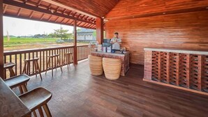 Un interior de madera con barra, asientos y vistas al exterior.