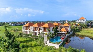 Un barrio residencial con varias casas, una piscina y abundante vegetación.
