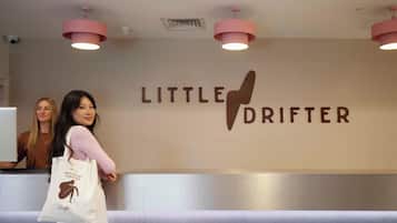 A reception area with a wall sign reading "LITTLE DRIFTER" and a white tote bag with a logo.