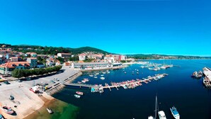 Une ville côtière dotée d’un port de plaisance, de bâtiments et d’un ciel bleu dégagé.