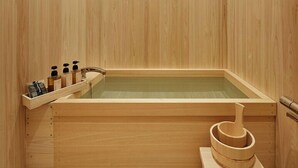 Une baignoire en bois, avec un banc en bois et un mortier et un pilon en bois.
