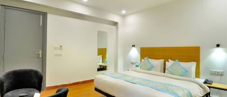 A hotel room with a bed, a chair, a ceiling fan, and a bedside table.