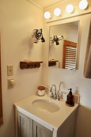 Enjoy a refreshing bathroom experience with a large mirror, sink, and hairdryer.