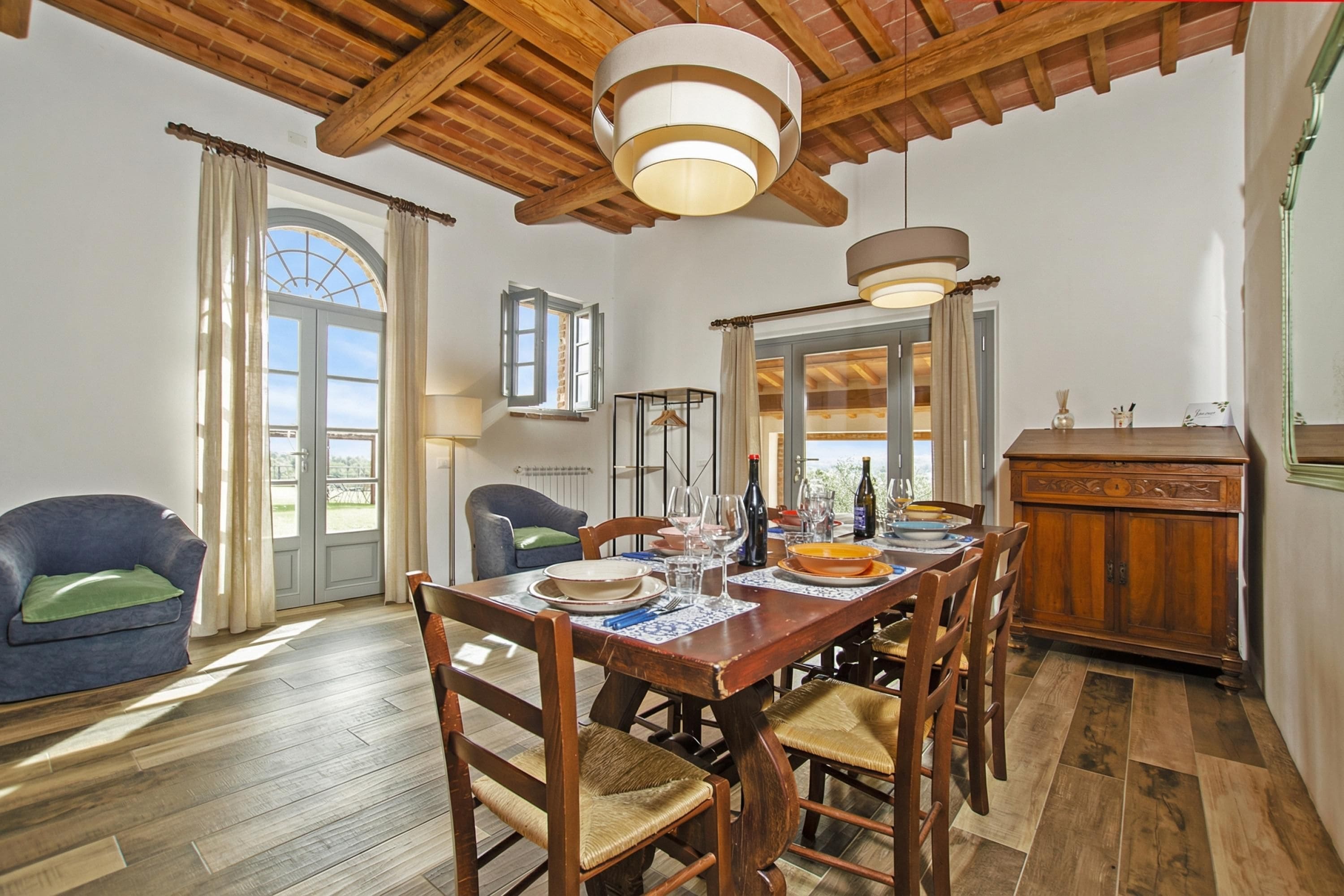A dining area with a wooden table, chairs, and a ceiling fan.
