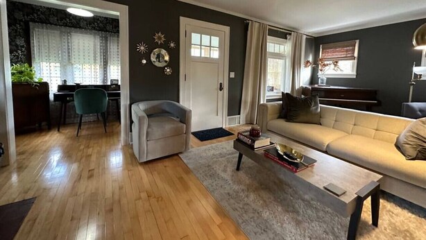 Amplia sala de estar con sofá, una mesa de centro y un comedor con una silla y una mesa.