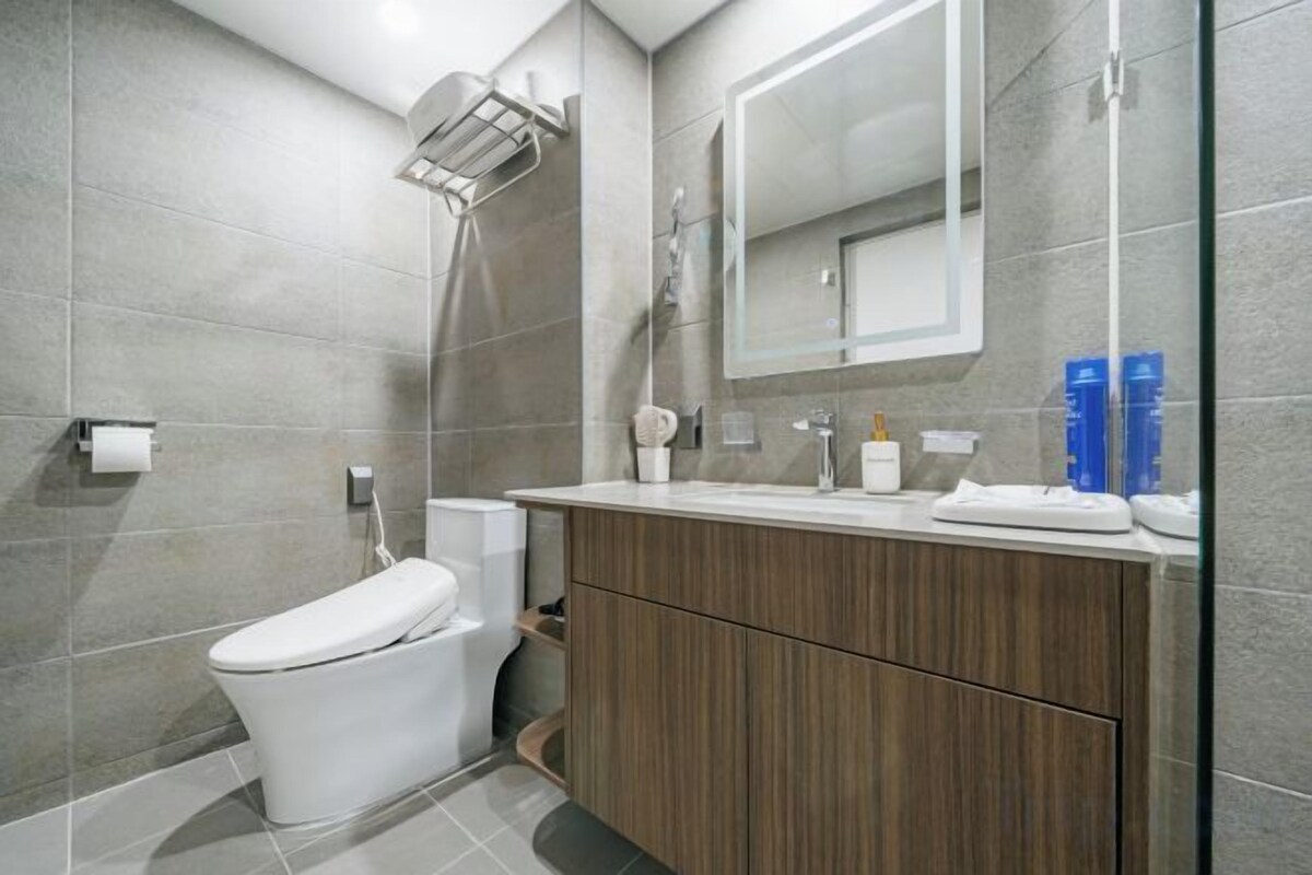 A modern bathroom with a toilet, shower, and vanity.