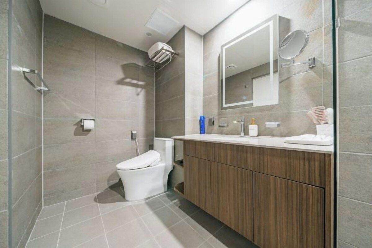 A modern bathroom with a shower, toilet, and vanity.