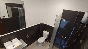 Ein modernes Badezimmer mit einer Duschkabine aus Glas, einem weißen Waschbecken und einer Toilette.