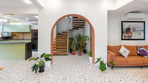 A modern interior with a kitchen, staircase, and living area. - Villa Reverie 6 Bedroom Ultra Modern (Betalbatim)