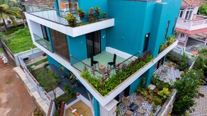 A modern two-story building with a flat roof, a balcony with outdoor seating, and a garden area. - Villa Reverie 6 Bedroom Ultra Modern (Betalbatim)
