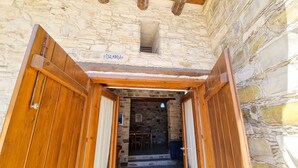 Un bâtiment en pierre avec une porte en bois et une enseigne sur laquelle on peut lire « TAMBRA ».