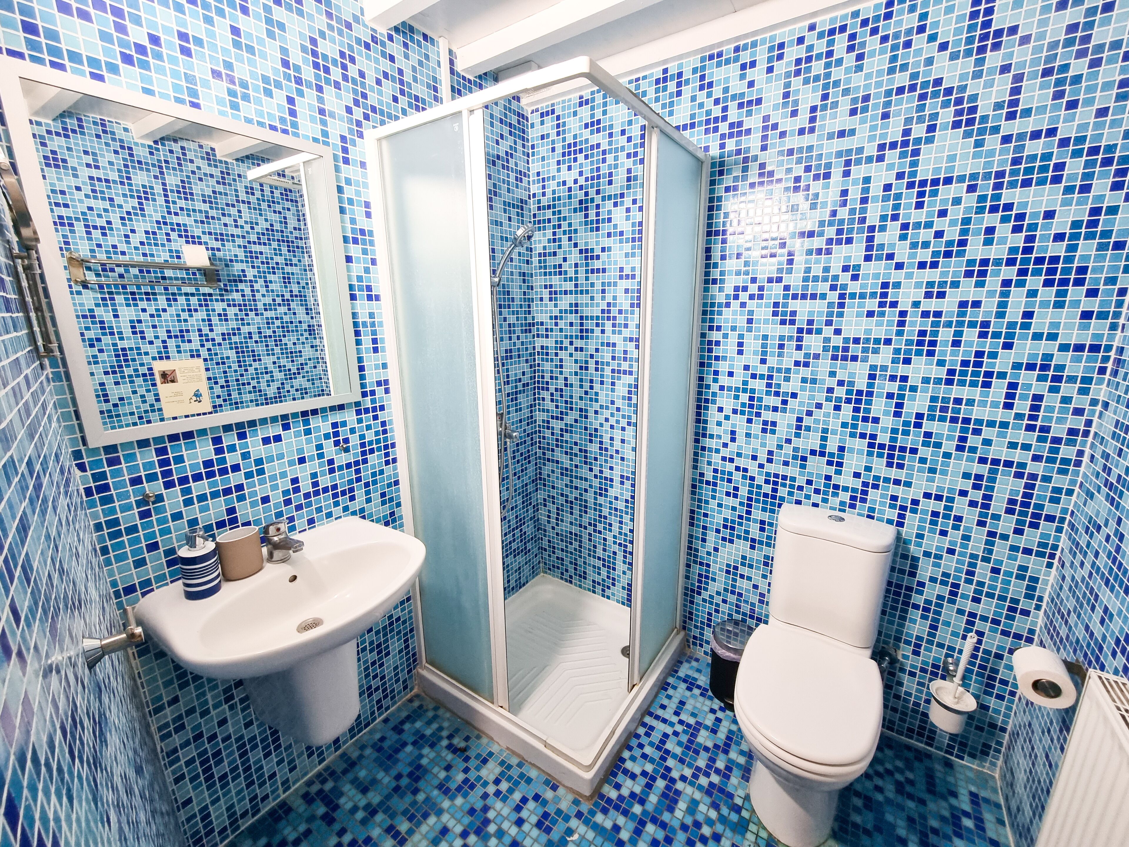 Un baño con lavamanos, inodoro y ducha.