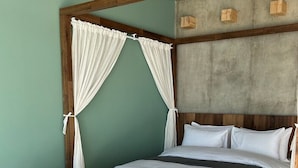 A room with a bed, two wicker chairs, and a canopy bed with white curtains. - W181Ocean Stay (Geoje)