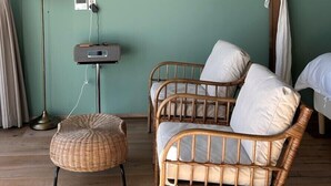 A room with a ceiling fan, wicker furniture, a lamp, and a radio on the wall. - W181Ocean Stay (Geoje)
