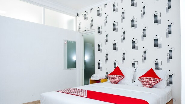 A modern hotel room with a large bed, white walls, and a patterned wallpaper. - Hotel O 111 Residence (Batu)