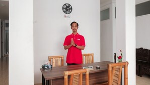 A hotel reception area with a wooden reception desk, a clock, and a 'No Smoking' sign on the wall. - Hotel O 111 Residence (Batu)