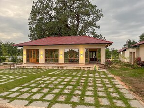 Una casa con techo de tejas, ventanas amplias y un césped cuidado.