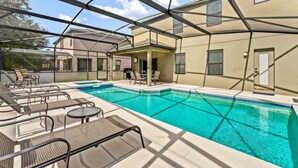 A pool area with lounge chairs and a covered seating area.
