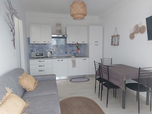 A modern kitchen with white cabinets, a built-in oven, and a blue-tiled backsplash.