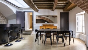 A modern kitchen with a large island, bar stools, and a dining area with chairs.
