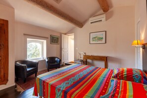 Une chambre à coucher avec un lit, un bureau, une chaise et une fenêtre.