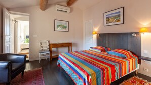 A bedroom with a bed, a desk, a chair, and a door leading to another room. - Apartment 'Gîte Durance' with Mountain View, Wi-Fi and Air Conditioning (Mallemort)