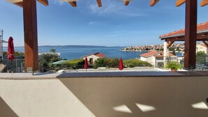 A covered outdoor area with a view of the sea and a town in the distance. - Heated infinity pool, family apartment with panoramic sea view a1 (Okrug Gornji)