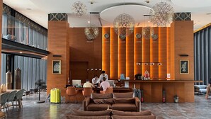 Un moderno vestíbulo de hotel con mostrador de recepción, zona de estar y un ventanal grande.