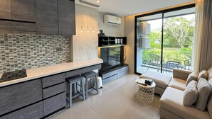 Una cocina moderna con una isla grande, electrodomésticos integrados y vistas al exterior.