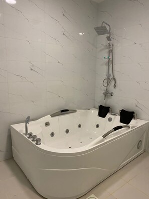 Junior-suite | Badeværelse | Separat badekar og bruser, designertoiletartikler, hårtørrer, hjemmesko