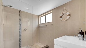 Une salle de bain moderne équipée d’une douche, d’une baignoire et d’un lavabo.