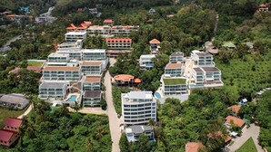 A resort with multiple buildings, including a large hotel with a swimming pool and several smaller structures. - Apartment at Kata Ocean View by Lofty (Karon)
