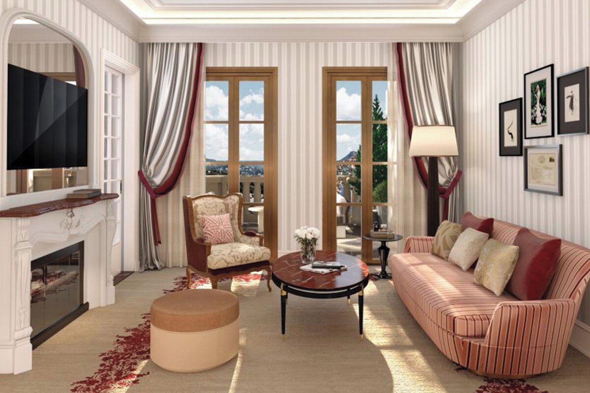A spacious living room with a fireplace, a television, a sofa, a chair, and a coffee table.