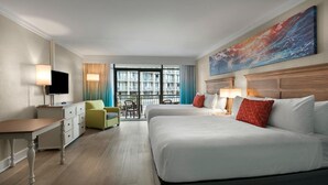 A hotel room with two beds, a desk, a chair, a TV, and a large window with a view of buildings. - Cozy North Ocean View Efficiency Vista 4th Floor (Myrtle Beach)