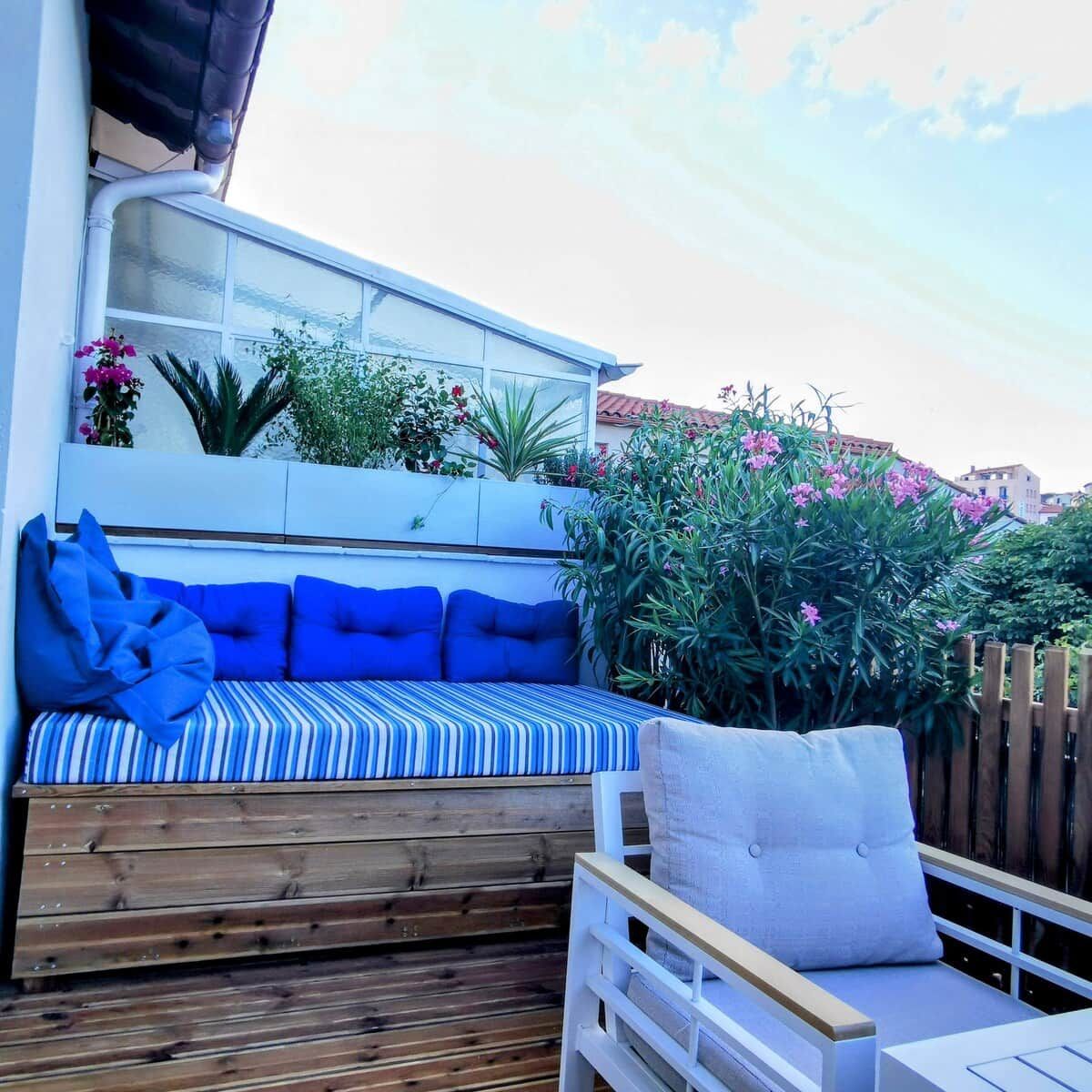 A wooden deck with a built-in bench and a white railing.