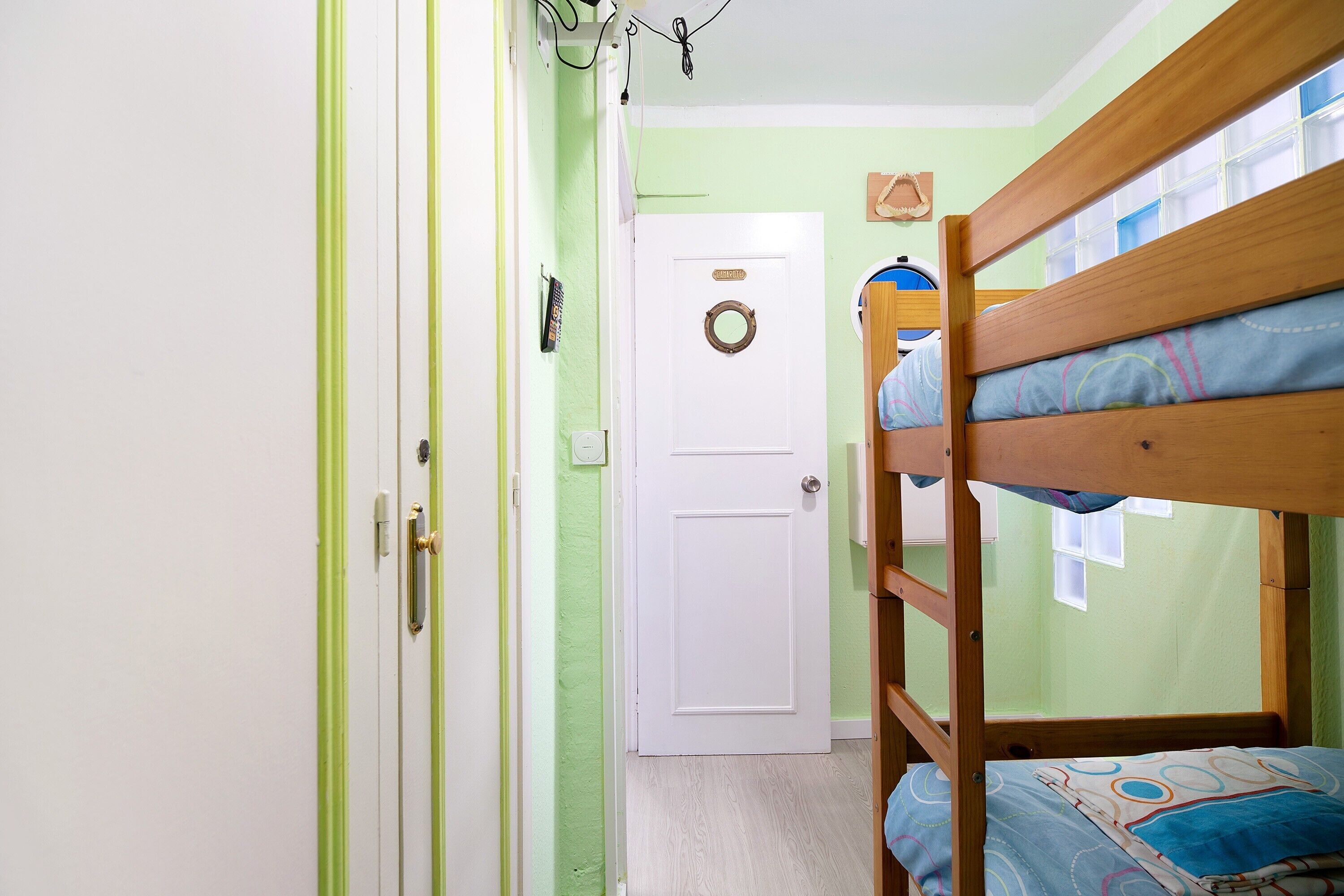Dormitorio con literas, puerta y ventana.