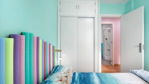 Une chambre à coucher comprenant un lit, une armoire et une porte donnant sur une salle de bain.