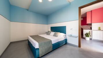 Un dormitorio moderno con una cama, mesita de noche y vistas a una zona de cocina.