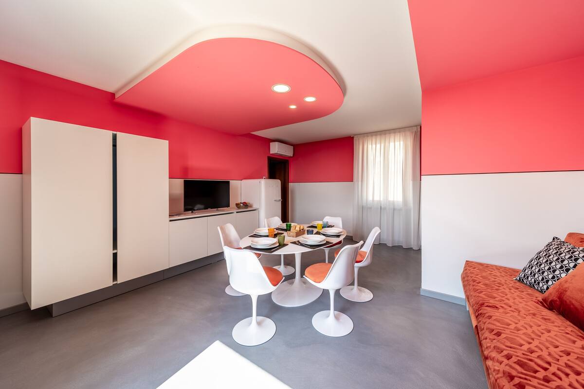 A modern kitchen with white cabinets and a dining area with white chairs.