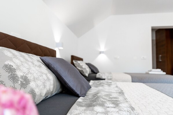Un dormitorio moderno con una cama grande, un cabecero de madera y dos lámparas de noche.