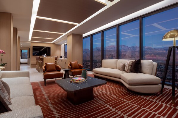 A modern living room with a large window, a sofa, a coffee table, and a TV. - Durango Casino & Resort (Las Vegas)